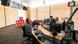 Broadcasting in action, from the glass box visible to passersby.